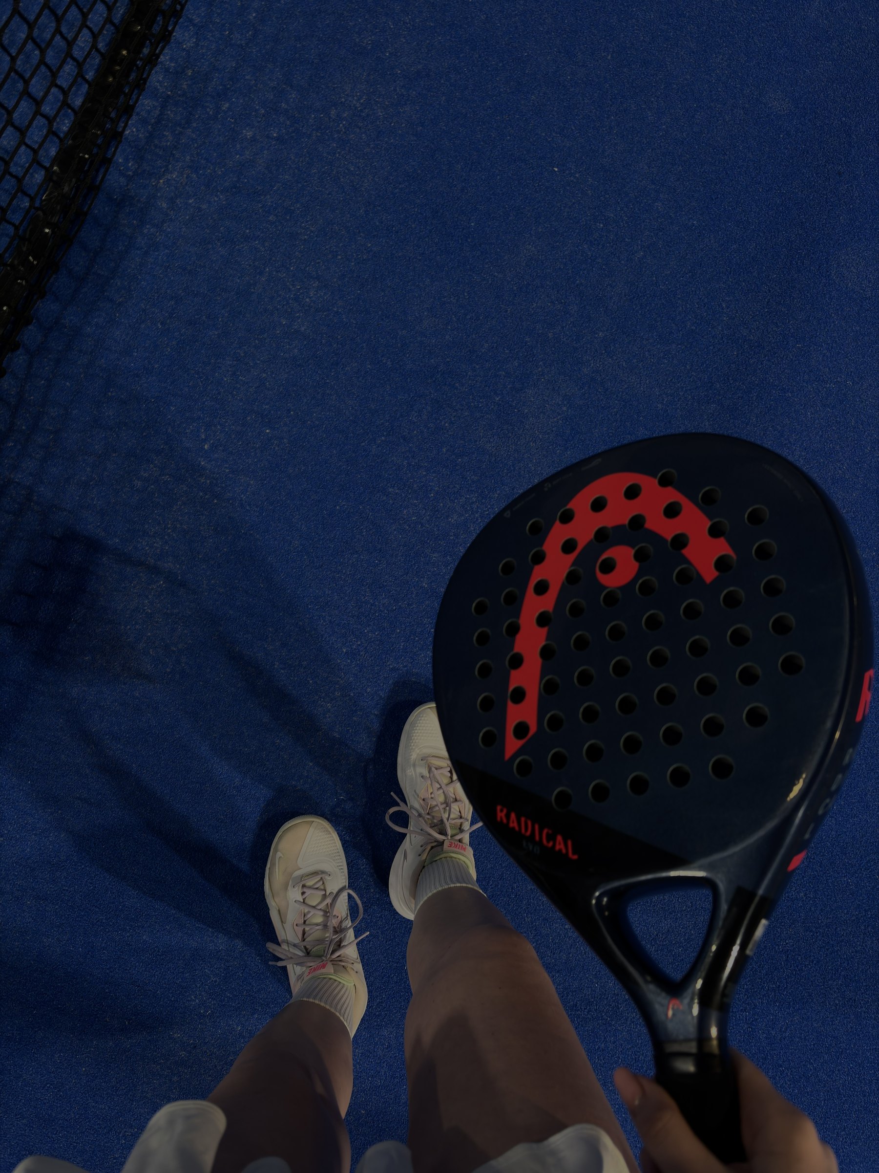 Padelschläger auf blauem Padelcourt